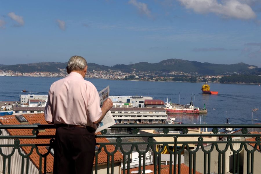 Persona mayor leyendo la prensa con vistas a la ría